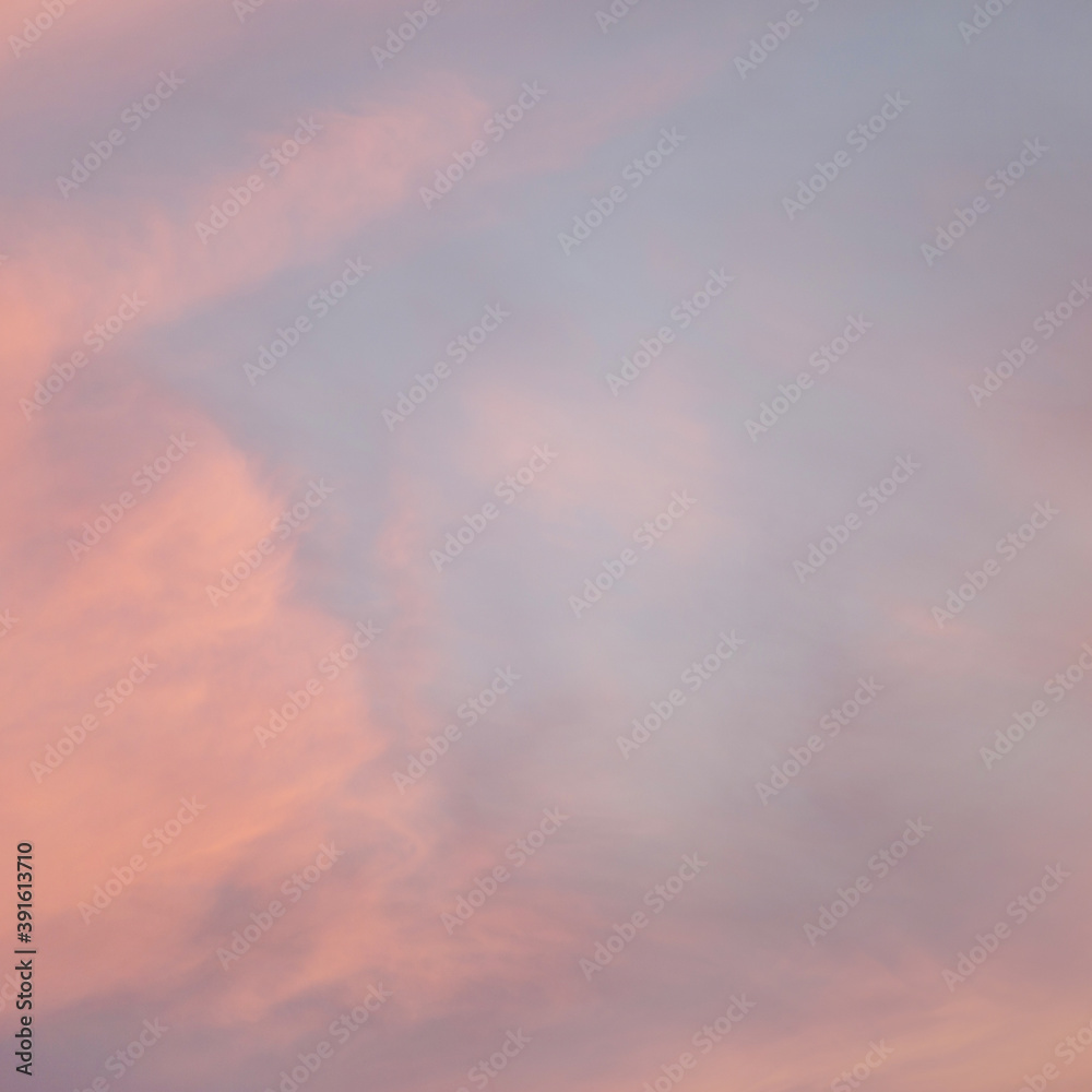 Beautiful evening sky with fluffy clouds and warm pastel colors. Abstract background for a daydreaming mood. Soft hues of blue and orange.