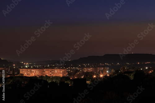 The city with lanterns in the mountainous area with a sunset or dawn sky