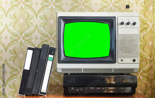 Old silver vintage TV with green screen to add new images to the screen, VCR on wallpaper background. 
