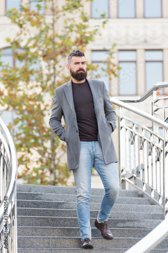 bearded hipster guy with stylish hairdo wear jacket and jeans for walking, beauty and fashion