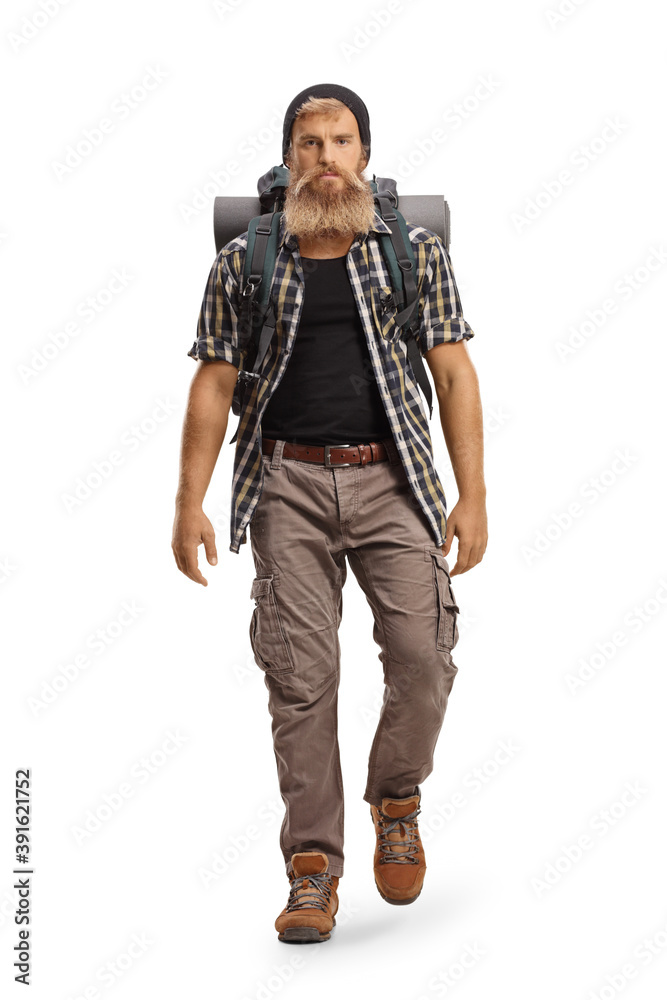 Young bearded hiker with a backpack walking towards camera Young bearded hiker with a backpack walking towards camera