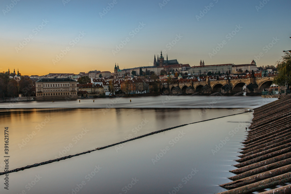 Postcard view of evening Prague panorama, capital of the Czech republic.Amazing European cityscape.Prague Castle,Charles Bridge,Vltava river at colorful sunset.Famous tourist destination.Urban scene.