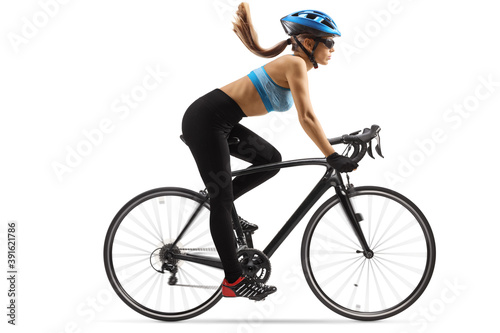 Young female cyclis riding a bicycle with a blue helmet photo