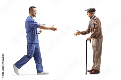 Male health worker welcoming an elderly man with a walking cane