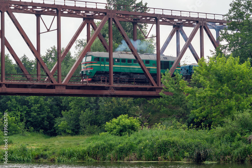 Freight train rides on a railway bridge over the river © andrei310