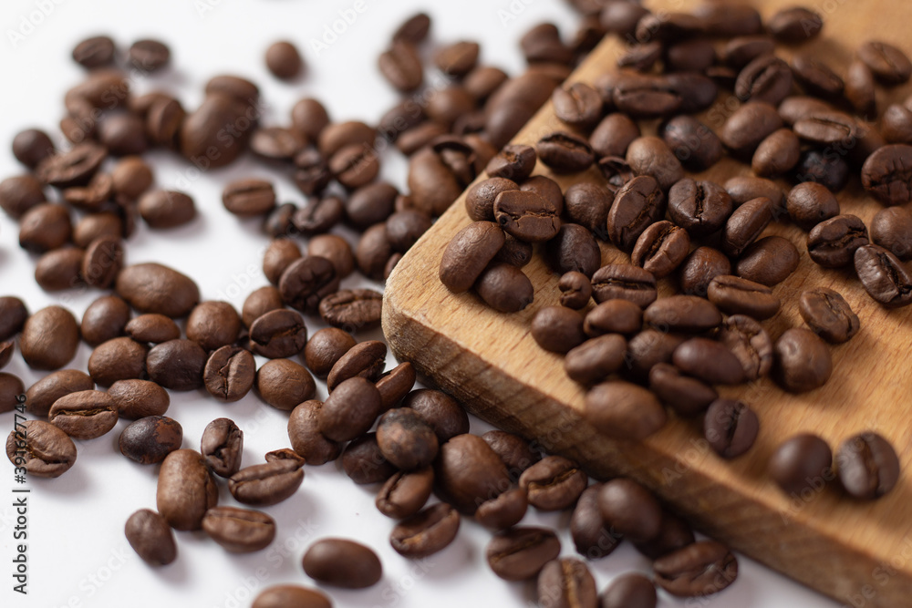 Close up of brown coffee beans on white table Close up of brown coffee beans on white table