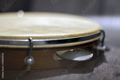 Close of Tambourine with platinelles on wooden table photo