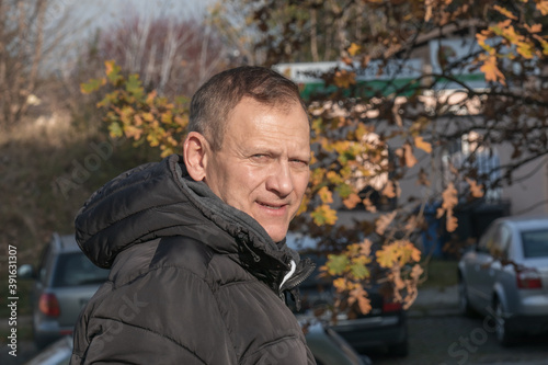 portrait of a middle-aged man against the background of an urban autumn landscape