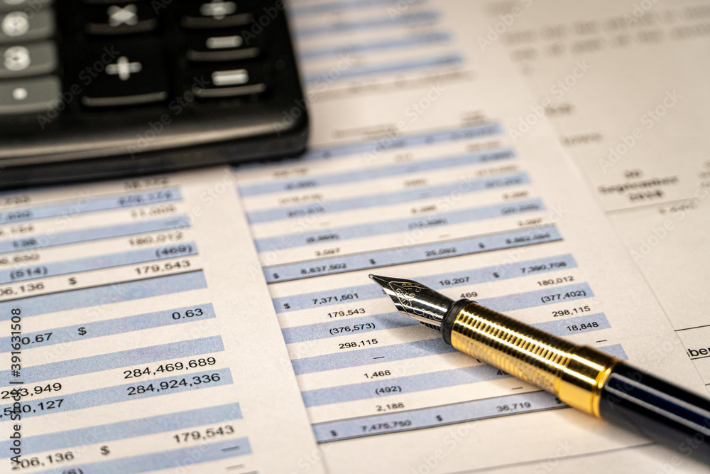 Fototapeta premium Calculator and pen with accounting report and financial statement on desk. Accounting business plan concept.