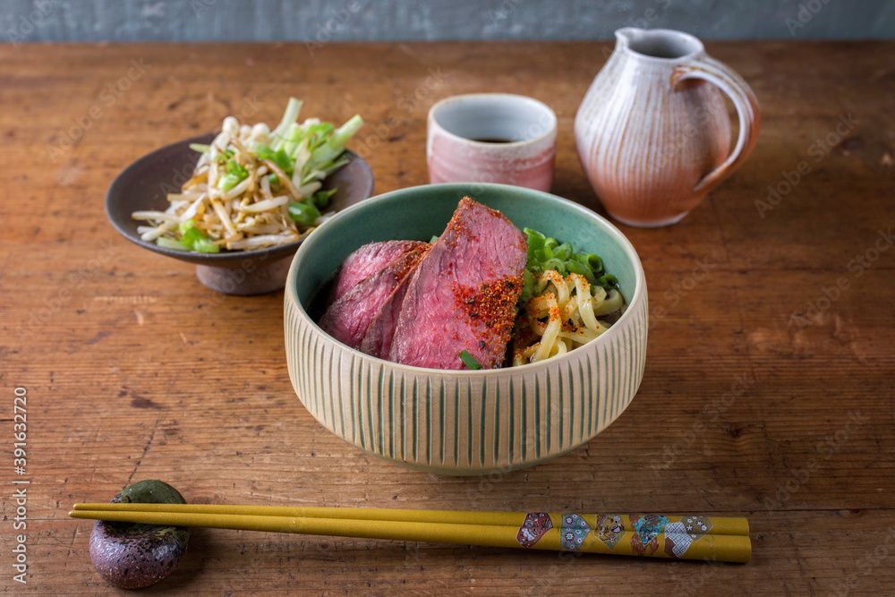 Modern style traditional Japanese ramen soup with wagyu beef filet and noodles served as close-up in a design bowl Modern style traditional Japanese ramen soup with wagyu beef filet and noodles served as close-up in a design bowl