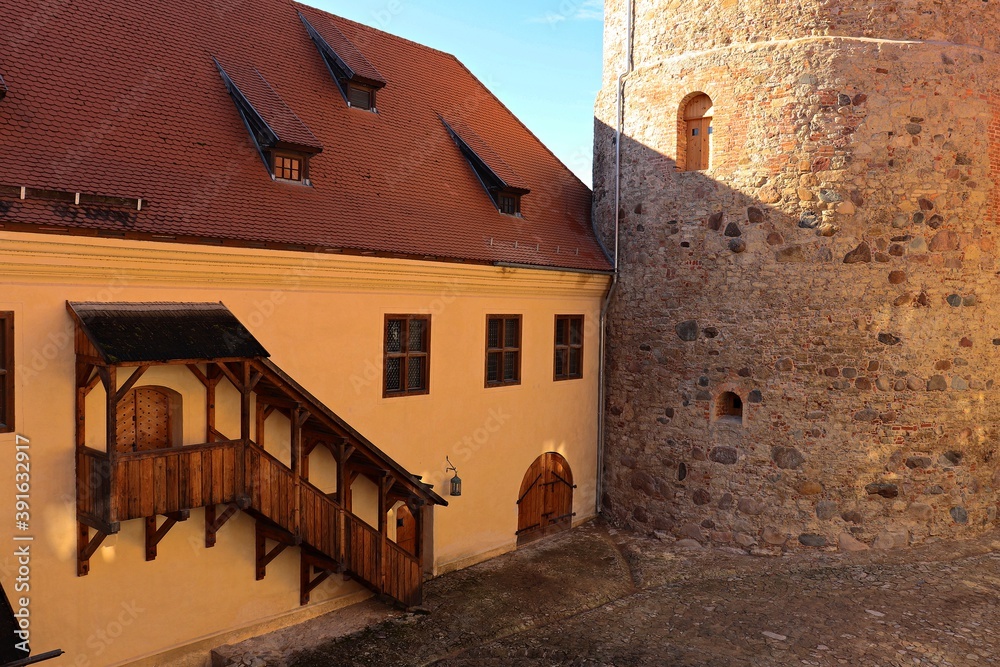 External wooden staircase leading to the second floor in the courtyard of the Bauska Castle, which is a landmark of Latvia in autumn 2020