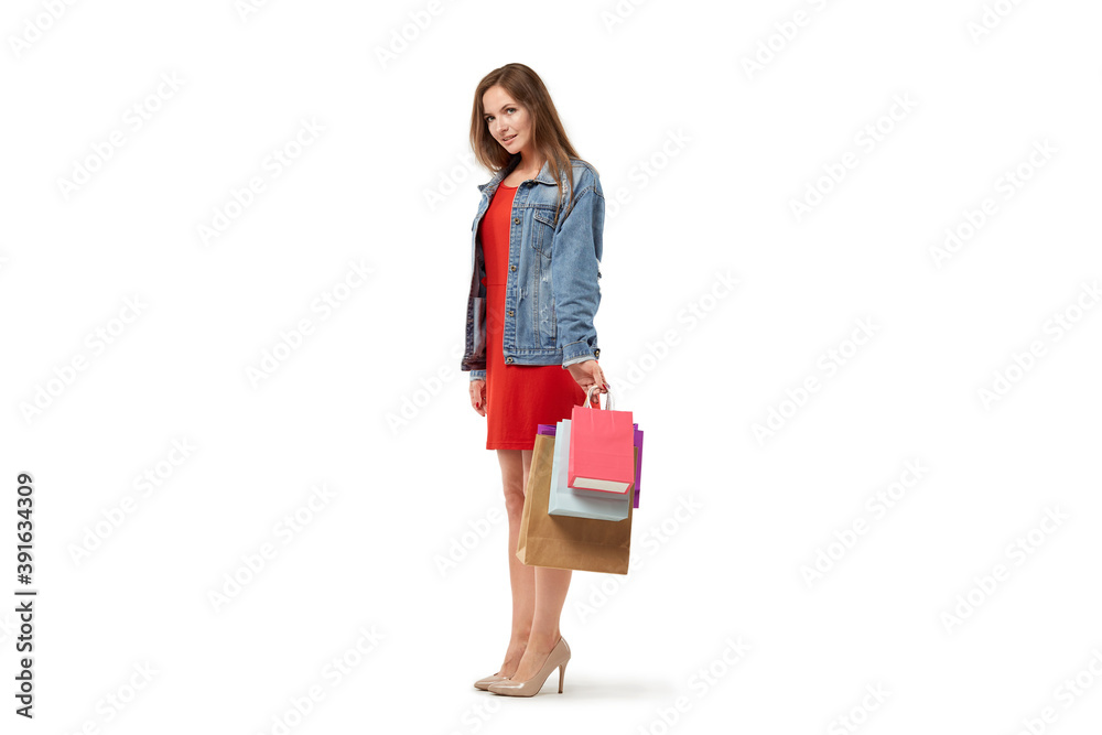 A woman with shopping bags in her hands in full growth. Enjoy shopping during the holidays. White isolated background.