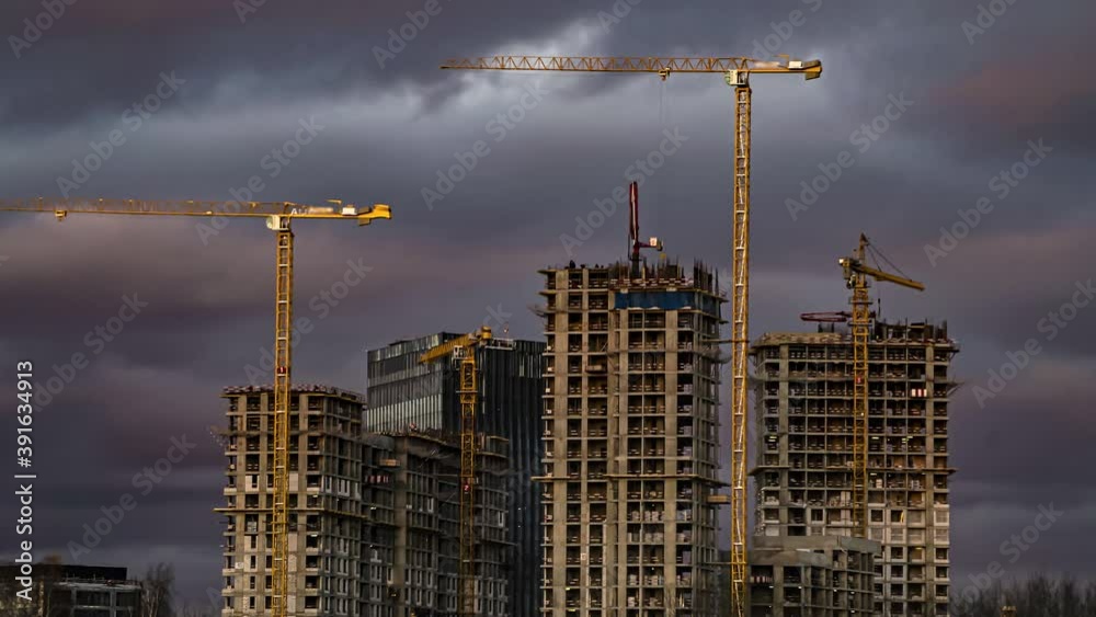 Cranes working day and night on construction of the housing estate in former industrial zone, time lapse