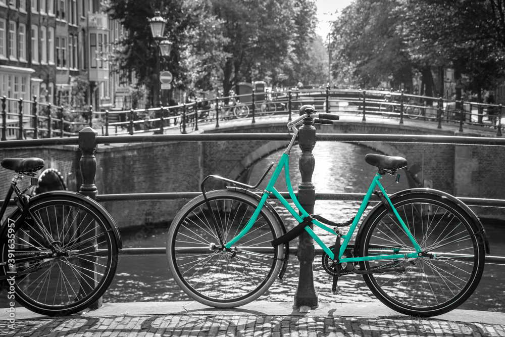 An azure bike on the streets of Amsterdam. Symbol for clean and ecological urban transport. Isolated in a black and white background. 