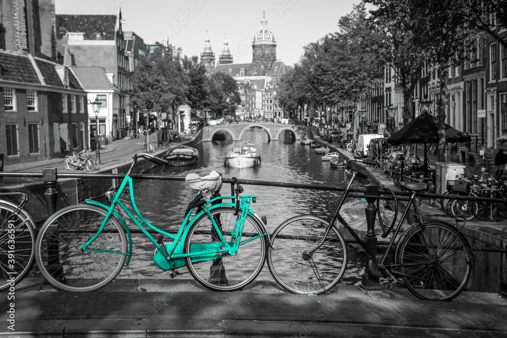 Fototapeta premium An azure bike on the streets of Amsterdam. Symbol for clean and ecological urban transport. Isolated in a black and white background.