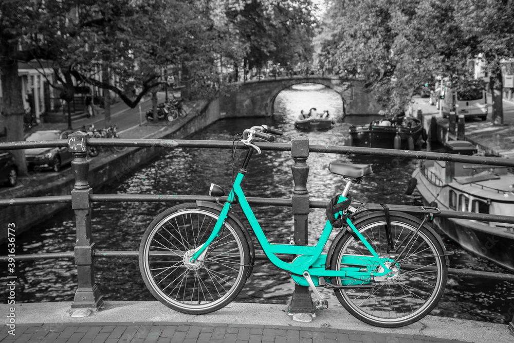 An azure bike on the streets of Amsterdam. Symbol for clean and ecological urban transport. Isolated in a black and white background. An azure bike on the streets of Amsterdam. Symbol for clean and ecological urban transport. Isolated in a black and white background.