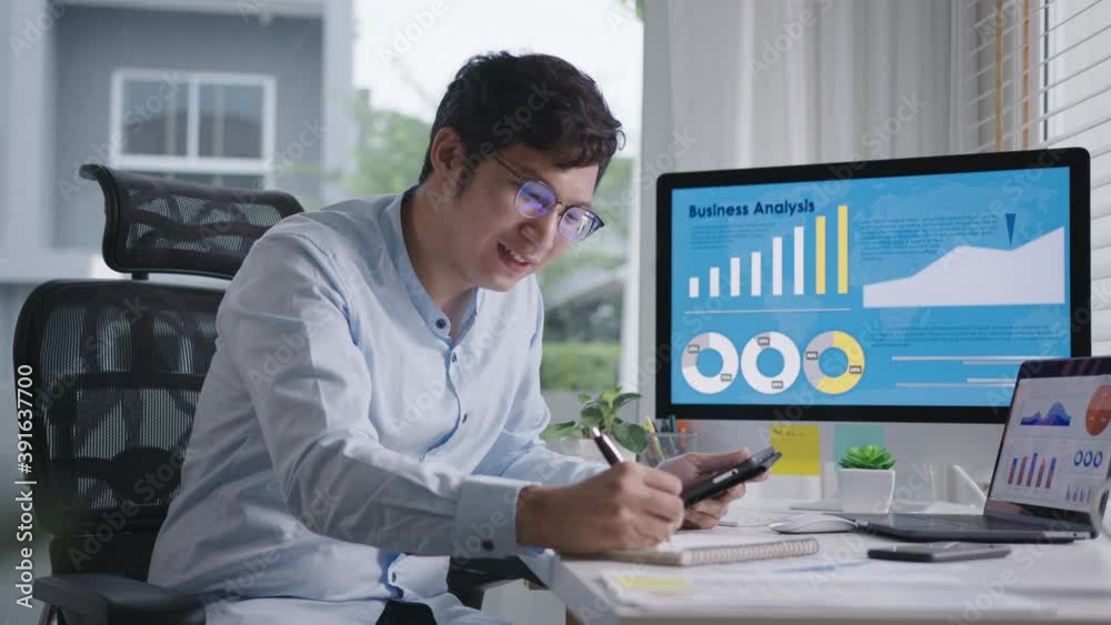 Young attractive asian thai man busy work multiple screen computer or smart tablet on table desk at home in freelance data analyst, data science scientist for business.