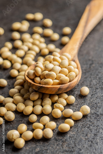 Dried soy beans in wooden spoon on black table. photo