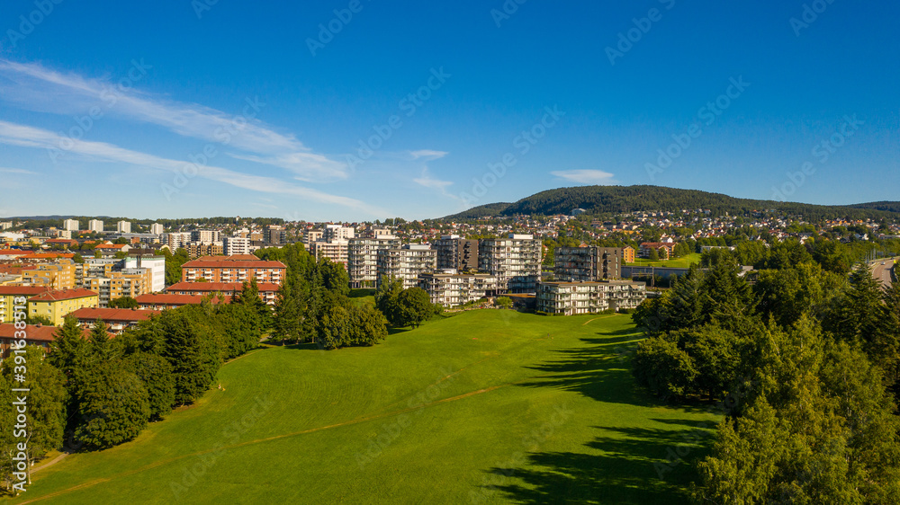 Oslo, Norway. Beautiful panoramic aerial view photo from flying drone for Oslo city new neighborhoods and new homes. Against the background of the mountains and blue sky on a sunny summer day. (Series