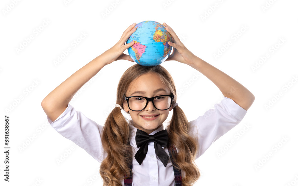 Exploring the world! Smiling school girl holding a globe above her head, isolated on white background. Exploring the world! Smiling school girl holding a globe above her head, isolated on white background.