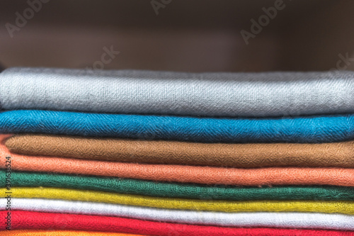 close up of colorful fabric,  a pile of cashmere textile, stack of colorful clothes, pile of clothes