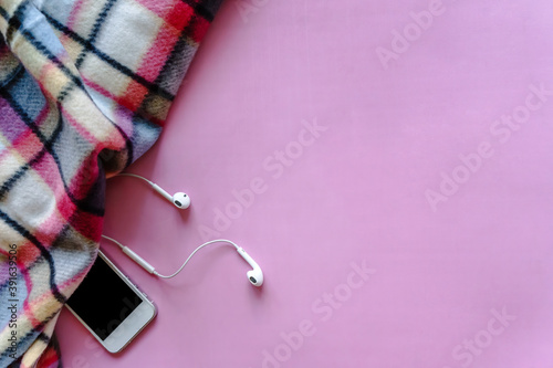 Cozy still life with plaid and gadgets on pink background