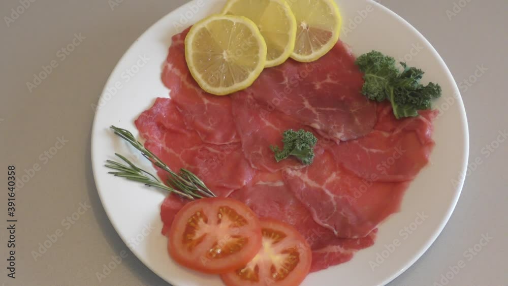 Carpaccio dish of thinly sliced pieces (slices) raw beef tenderloin Carpaccio dish of thinly sliced pieces (slices) raw beef tenderloin