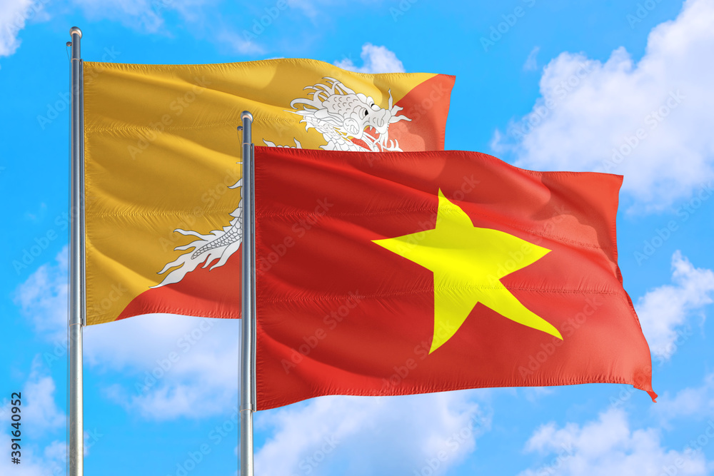 Vietnam and Bhutan national flag waving in the windy deep blue sky. Diplomacy and international relations concept. Vietnam and Bhutan national flag waving in the windy deep blue sky. Diplomacy and international relations concept.