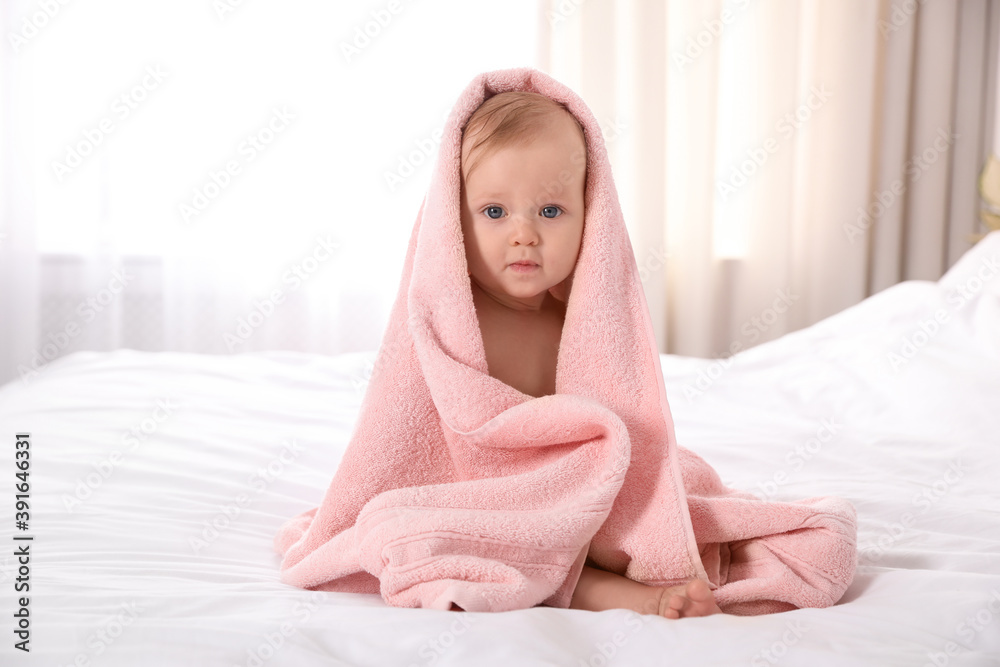 Cute little baby with soft pink towel on bed after bath Cute little baby with soft pink towel on bed after bath