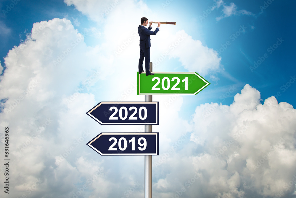 Road sign and businessman with 2020 and 2021