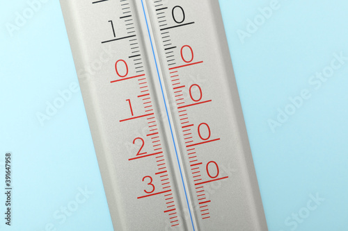 Weather thermometer on light blue background, closeup