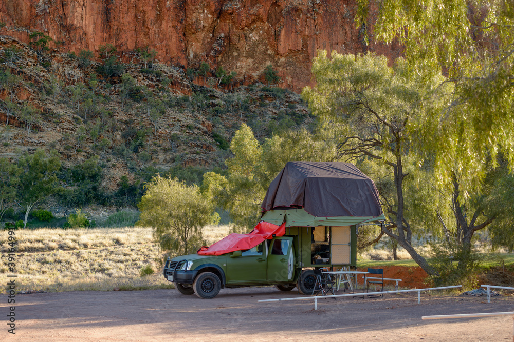 A four wheel drive camper van parked close to eucalyptus trees growing in rural Northern Terroties in Australia.