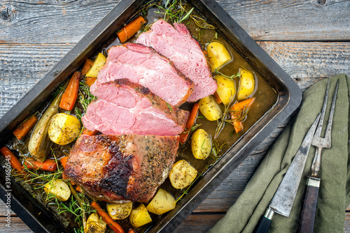 Quadro su tela Traditional corned pot pork roast sliced and served with potatoes, carrots and f