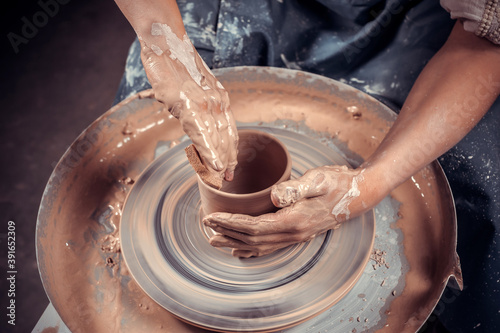 hands of potter do a clay pot photo