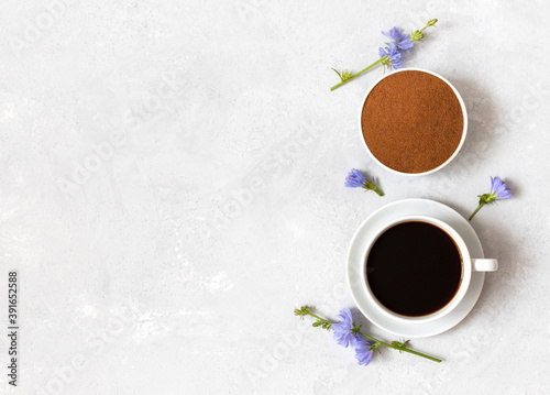 Chicory coffee drink, powder and blue flowers on a white background. Healthy beverage, coffee substitute. Copy space, top view