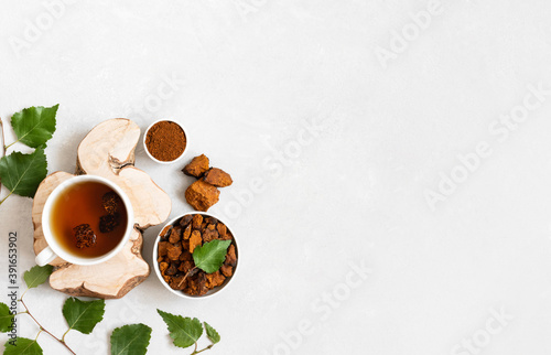Chaga tea on a white background. Traditional Russian drink with pieces of birch mushroom. Copy space, top view, flat lay.