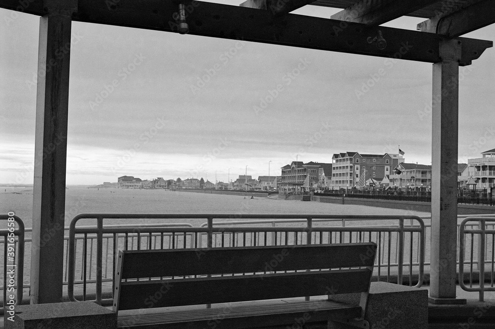 Obraz premium Empty bench with a view of Hampton Beach and boardwalk