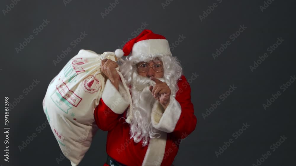 Papa noel con bolsa de regalos apuntando 