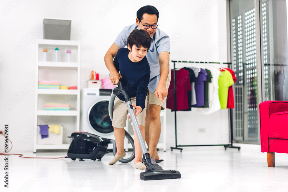 Father teaching asian kid little boy son having fun doing household chores cleaning and washing floor wiping dust with vacuum cleaner while cleaning house together at home.Housework concept