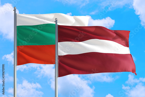 Latvia and Bulgaria national flag waving in the windy deep blue sky. Diplomacy and international relations concept.