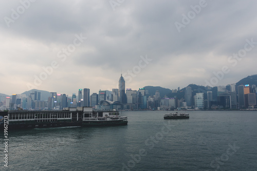panoramic city skyline with ferries during cloudy weather