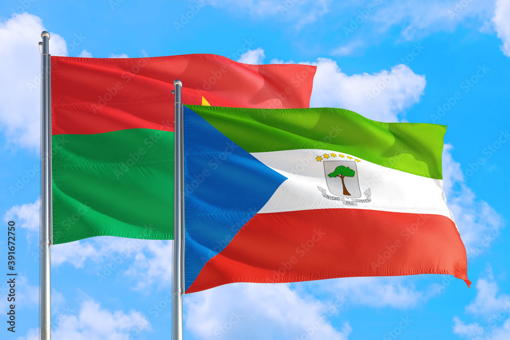 Equatorial Guinea and Burkina Faso national flag waving in the windy deep blue sky. Diplomacy and international relations concept. Equatorial Guinea and Burkina Faso national flag waving in the windy deep blue sky. Diplomacy and international relations concept.