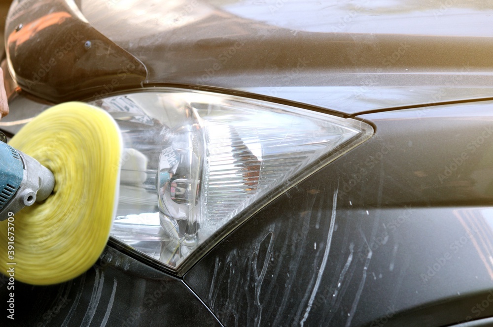 Big headlight cleaning on the car with power buffer machine at service station,Before and after