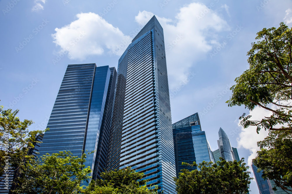office buildings. Looking Up At Modern Corporate Buildings On A Sunny Day, With Dramatic Clouds, In Singapore. Stock Photo..