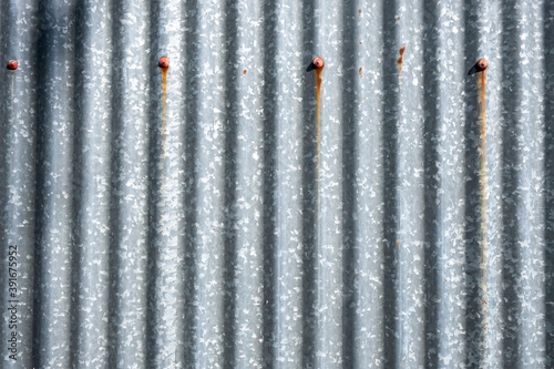 rusty metal background. Minimalist Detail Of Weathered Corrugated Zinc Roof Sheet With Soft Sunlight  Backgrounds  Textures. Stock Photograph.