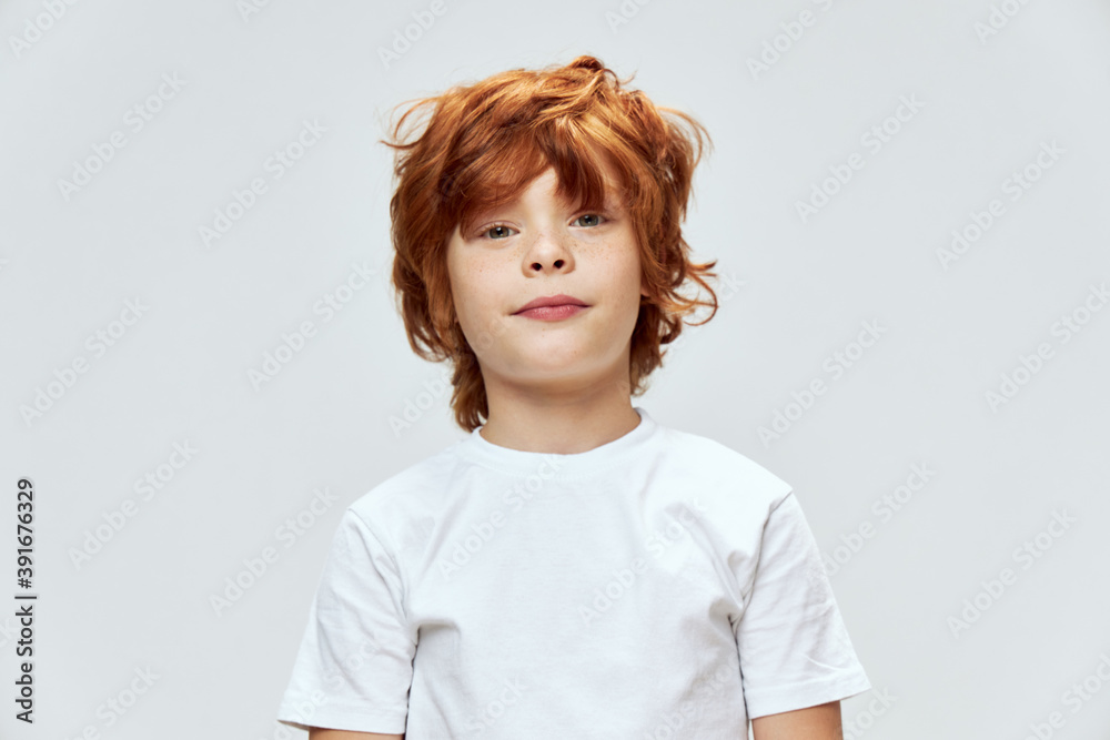 Red-haired boy with tousled hair cropped view white t-shirt close-up