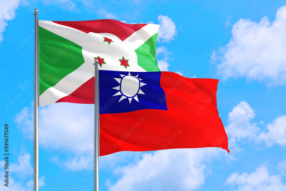 Naklejka premium Taiwan and Burundi national flag waving in the windy deep blue sky. Diplomacy and international relations concept.