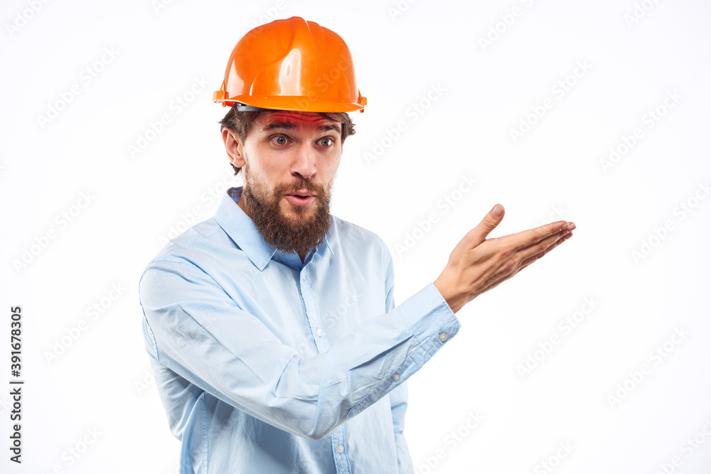 A man in an orange helmet shirt construction industry worked light background A man in an orange helmet shirt construction industry worked light background