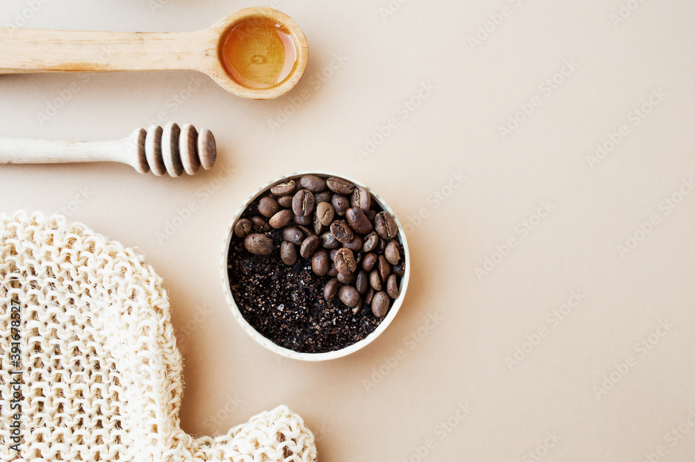 Coffee scrub in gold jar, honey, cosmetic oil, wooden stick for honey and rough massage glove against pastel beige background, home cosmetics, cosmetic layout anti-cellulite products, selective focus Coffee scrub in gold jar, honey, cosmetic oil, wooden stick for honey and rough massage glove against pastel beige background, home cosmetics, cosmetic layout anti-cellulite products, selective focus