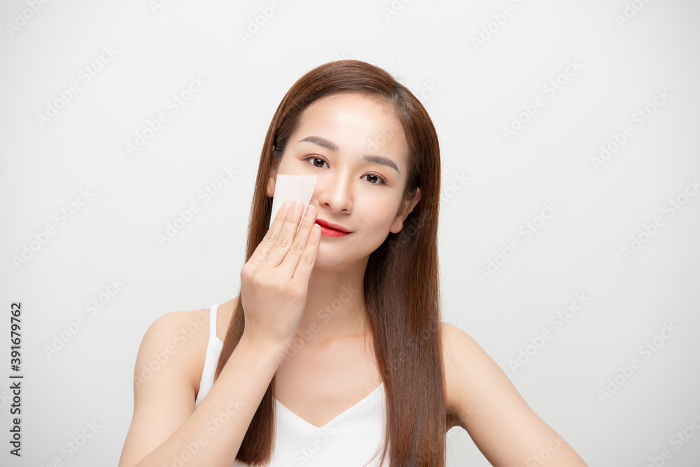 Portrait of young Asian woman with skin care using oil blotting paper over white background. Portrait of young Asian woman with skin care using oil blotting paper over white background.
